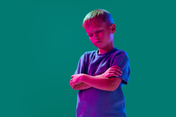 小男孩的肖像，孩子站在蓝色的霓虹灯工作室背景悲伤的脸图片下载