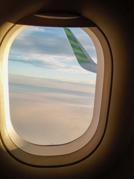 从云层上方的飞机窗户内看到的景象图片下载