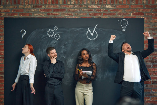 一群员工站在黑板前，画着商业图标，从事项目，产生想法，解决问题图片下载