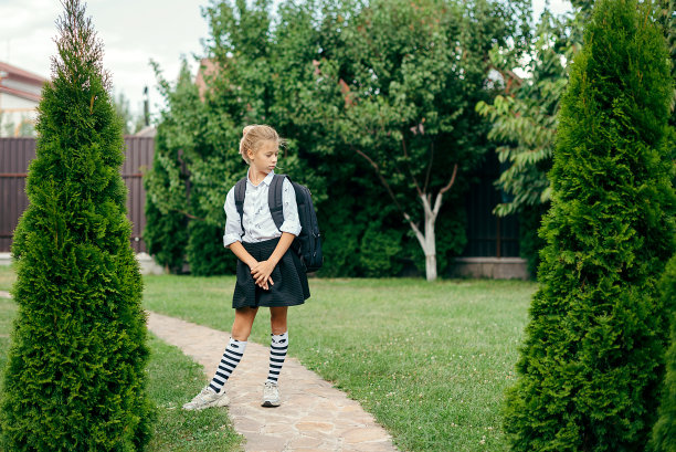 回到学校。可爱的小女孩背着双肩包开心地去上学图片下载