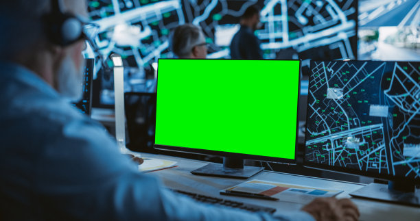 中年监控专家在绿屏模拟显示的电脑上工作。经理有效地多任务处理支持客户的电话和电脑工作图片下载