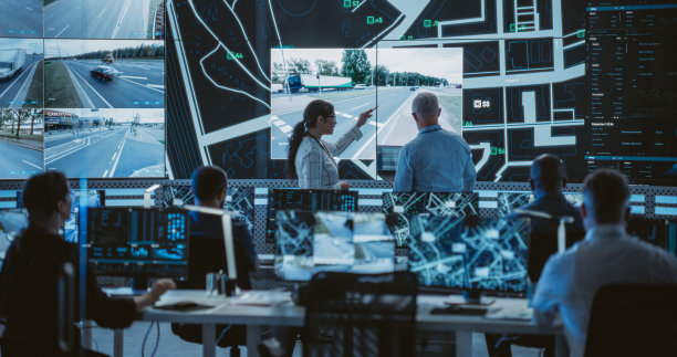 在现代物流技术公司工作的软件开发人员，工程师和数据科学家团队。男男女女在监控录像的屏幕前讨论图片下载