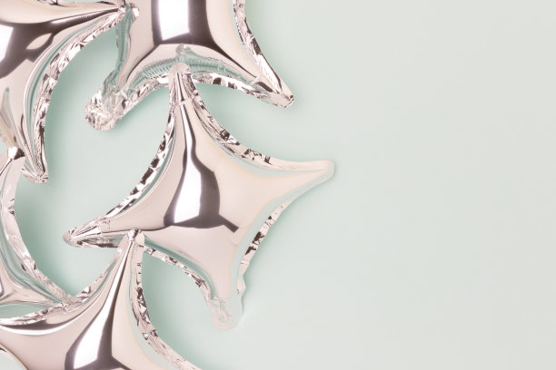 蓝色背景上的银色充气星星气球。图片下载