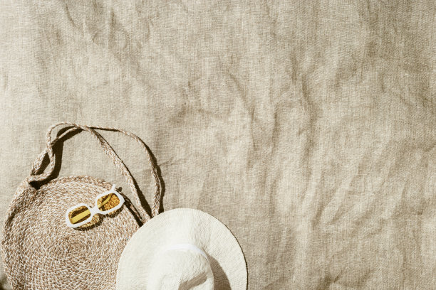 暑假，海滩休息的概念，极简的风格美学平铺时尚稻草沙滩包和潮流黄色太阳镜沙滩巾在阳光下，复古色调的照片，俯视图，空间图片下载