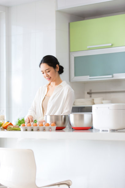 年轻的家庭主妇在厨房里准备食物的照片图片下载