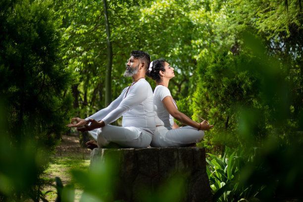 印度男人和女人一起在绿色的森林里做瑜伽冥想练习。健身和健康的生活方式。图片下载