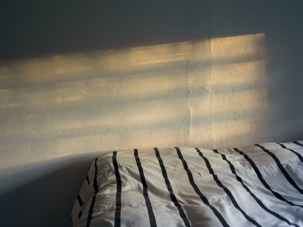 窗框的阴影和床上夕阳的余晖图片下载