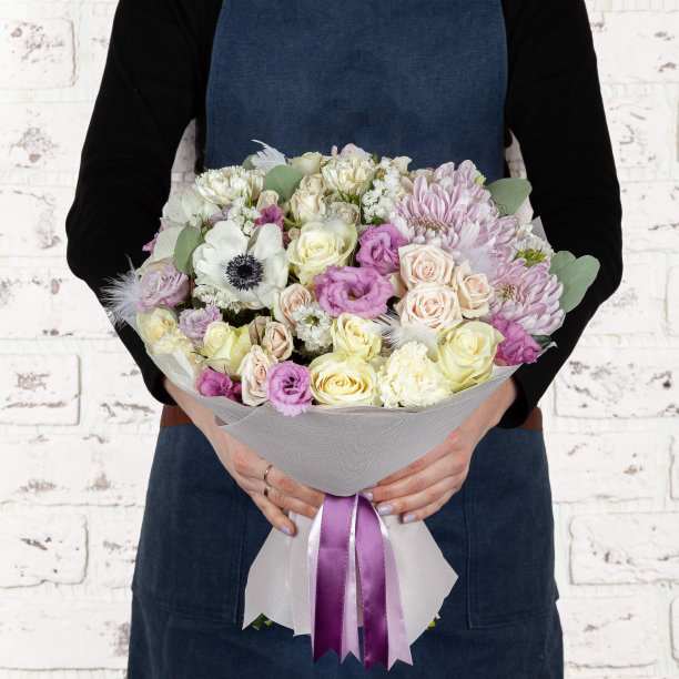 女花商持有新鲜的鲜花盛开的花束在砖墙的背景图片下载