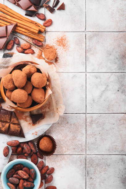 巧克力松露与可可粉在木制盘子在旧裂瓦桌子背景。美味甜美的巧克力松露糖果。情人节和母亲节的概念与拷贝空间。前视图。图片下载