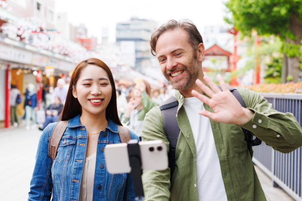 白人男子和亚洲女子用手机自拍图片下载