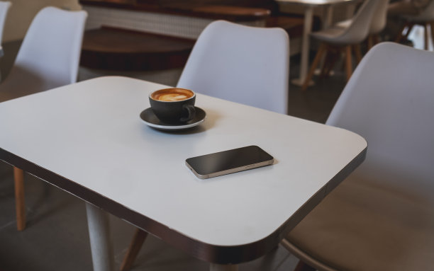 一个手机和咖啡杯在咖啡馆的桌子上图片下载