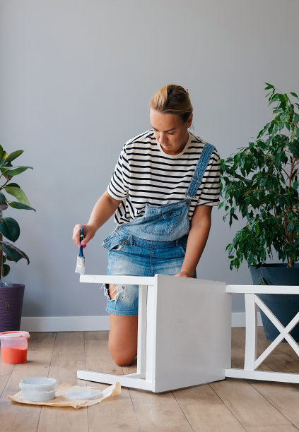 妇女在家里升级家具，画木椅图片下载