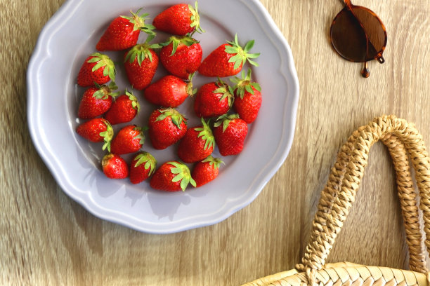 草莓，太阳镜和稻草袋图片下载