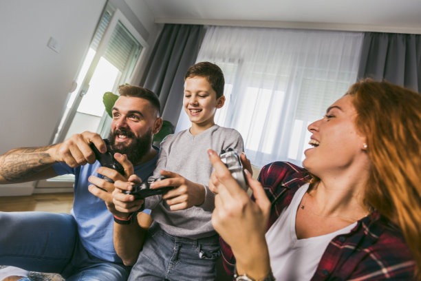 有趣的家庭在客厅里一起玩电子游戏。图片下载
