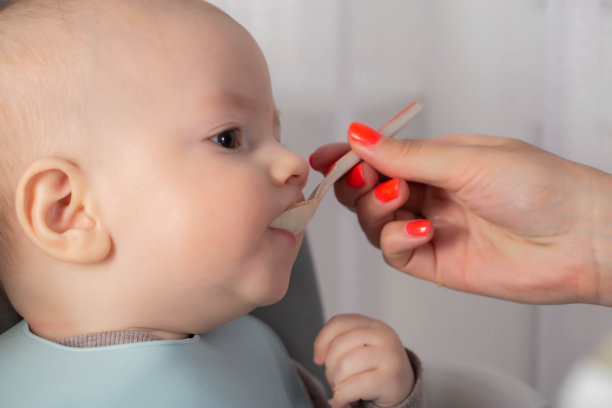 第一次给6个月大的男婴喂食水果泥(特写)。文本复制空间图片下载