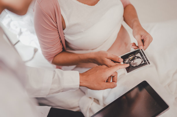 男医生展示超声波图片，并为医院里的孕妇做检查图片下载