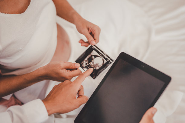 男医生展示超声波图片，并为医院里的孕妇做检查图片下载