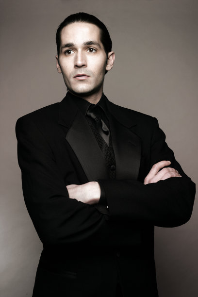 穿着黑色燕尾服、双臂交叉的男人图片下载