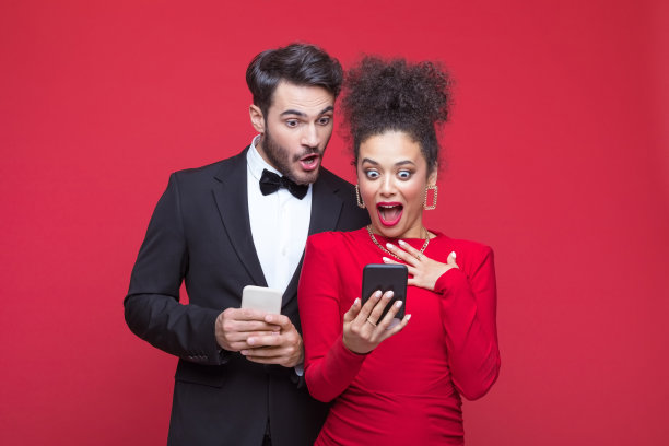 惊讶的夫妇使用智能手机的照片图片下载