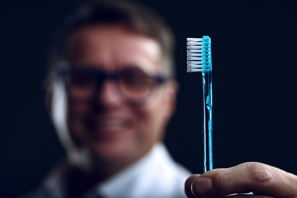 蓝色牙刷聚焦，牙医模糊图片下载