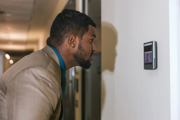 一名男子用面部扫描仪打开办公楼的门。门禁面部识别系统。用于安防系统的生物识别导纳控制装置。生物识别导纳控制装置图片下载