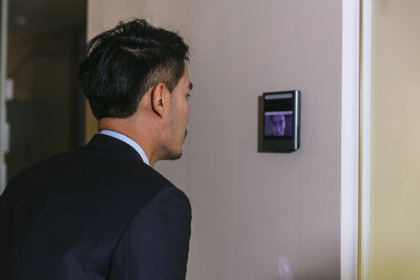 一名男子用面部扫描仪打开办公楼的门。门禁面部识别系统。用于安防系统的生物识别导纳控制装置。生物识别导纳控制装置图片下载