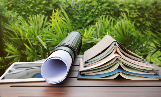 工作教育书的堆叠，在绿色背景的桌子上绘制蓝图和平板电脑图片下载