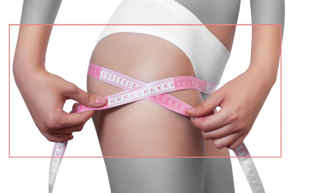 一个瘦弱的女人用黄色和黄色的卷尺在白色孤立的背景上测量她的臀部。减少肥胖和肥胖。健康的生活方式。图片下载