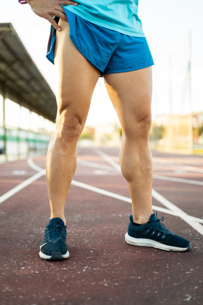 一个无法辨认的运动员在户外跑道上摆姿势的强壮的腿的照片。运动、运动和健康生活的理念。壁纸。图片下载