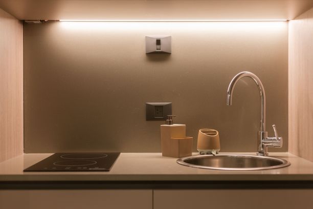 现代厨房，炉灶上方有灯具和水龙头。图片下载