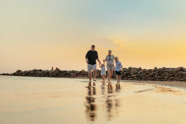 不错的高加索家庭在日落的时候在海上跑步。和孩子们一起过暑假。高质量的照片图片下载