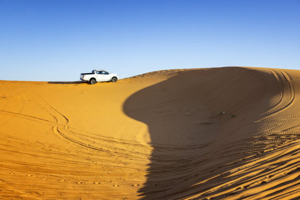在沙漠中的沙丘上行驶的汽车，Merzouga, Erg Chebbi，撒哈拉，摩洛哥图片下载