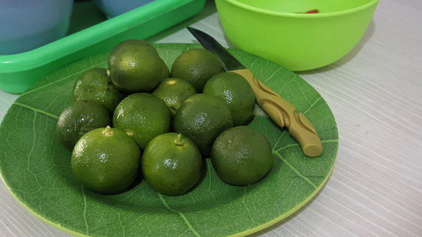 印尼小青柠水果放在盘子里用刀切图片下载