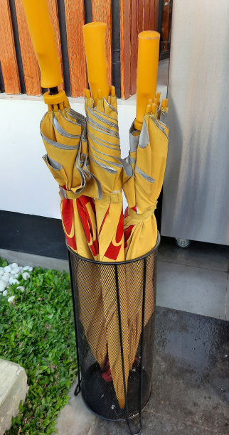 黄色雨伞放在入口处的篮子里图片下载