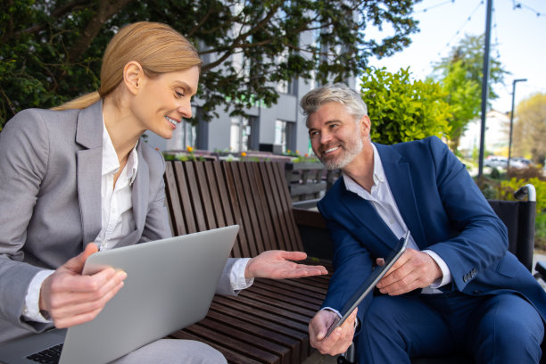 坐在轮椅上的商人和女伙伴使用笔记本电脑和平板电脑共同完成项目图片下载
