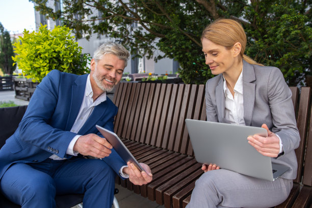 坐在轮椅上的商人和女伙伴使用笔记本电脑和平板电脑共同完成项目图片下载