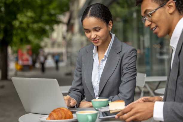 深色头发的女人和她的同事在早餐时讨论业务问题图片下载