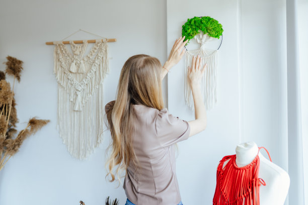 自由职业者在半成品的编织品上工作。创意针织理念。在家庭工作室里编织编织的时髦女人。波希米亚风格的装饰在编织过程中。图片下载