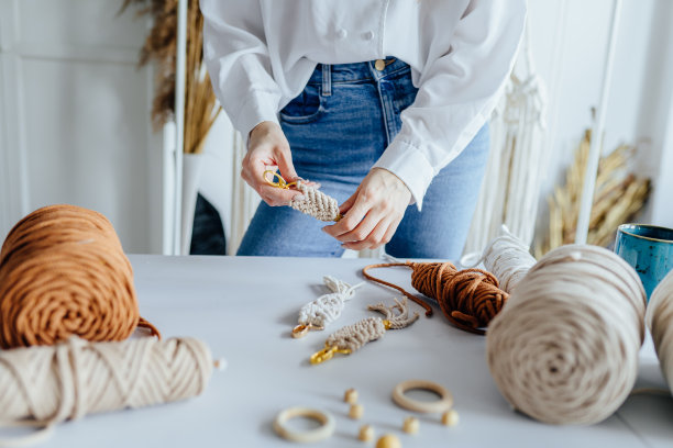 一个无法辨认的女人在做编花时的手。天然棉线。手工编织在工作过程中。图片下载