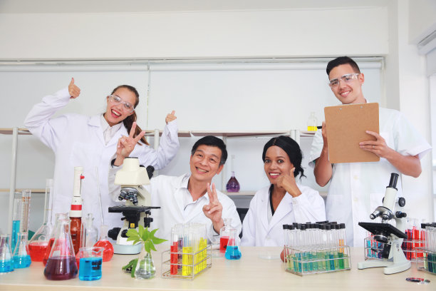 实验室里快乐的科学团队，现代实验室里快乐微笑的科学家和研究人员，实验室里混合种族的研究人员团队图片下载