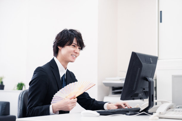 商人一边工作一边用扇子扇自己图片下载