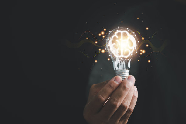 一只手拿着发光的灯泡，象征着创意之间的联系图片下载