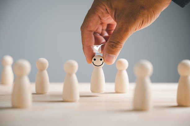 手从人群中选择一个木制人物作为被选中的领导者图片下载