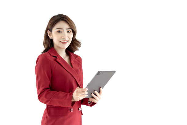 年轻的亚洲女性，公司员工，穿着红色套装，微笑着，拿着数码平板电脑，站在白色的背景上图片下载
