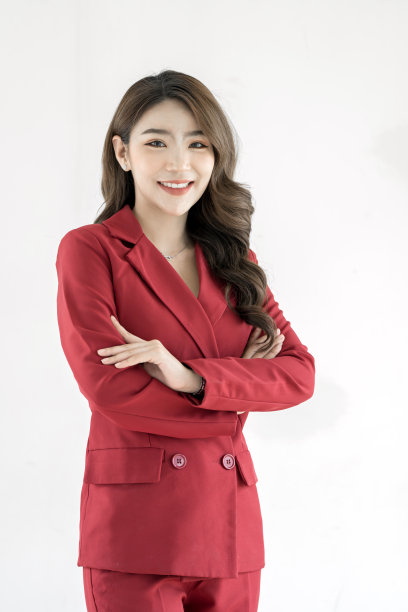 穿着红色套装的快乐年轻女商人在白色背景上摆出孤立的姿势。图片下载