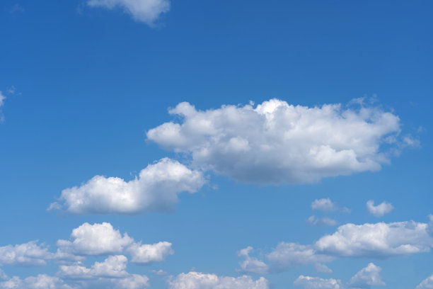 白色蓬松的云朵在黑色的背景和蓝色的天空下显得格外显眼图片下载