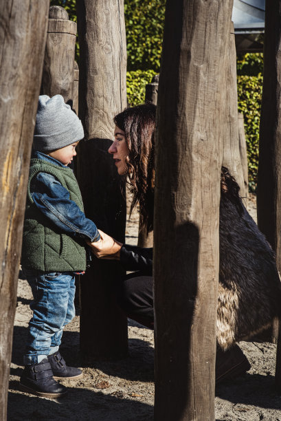 在操场上，妈妈拉着孩子的小手，平静地和孩子说话。母子之间的对话强调了家庭关系中建设性对话的重要性图片下载