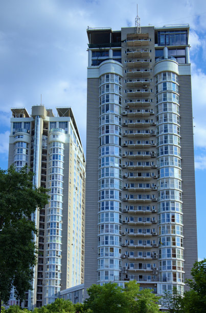 现代高层住宅的低角度景观。蓝天白云的背景。玻璃和钢铁的现代建筑。基辅，Obolon社区的房地产概念图片下载