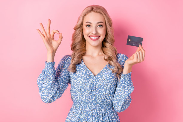 照片有趣的年轻迷人的女士金发ok的标志持有塑料卡交易业务工作工资孤立在粉红色的背景图片下载