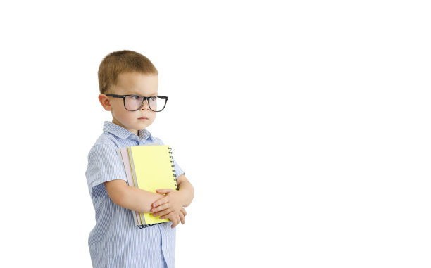 一个戴着眼镜、手里拿着笔记本的小男孩被孤立在白色背景上。图片下载